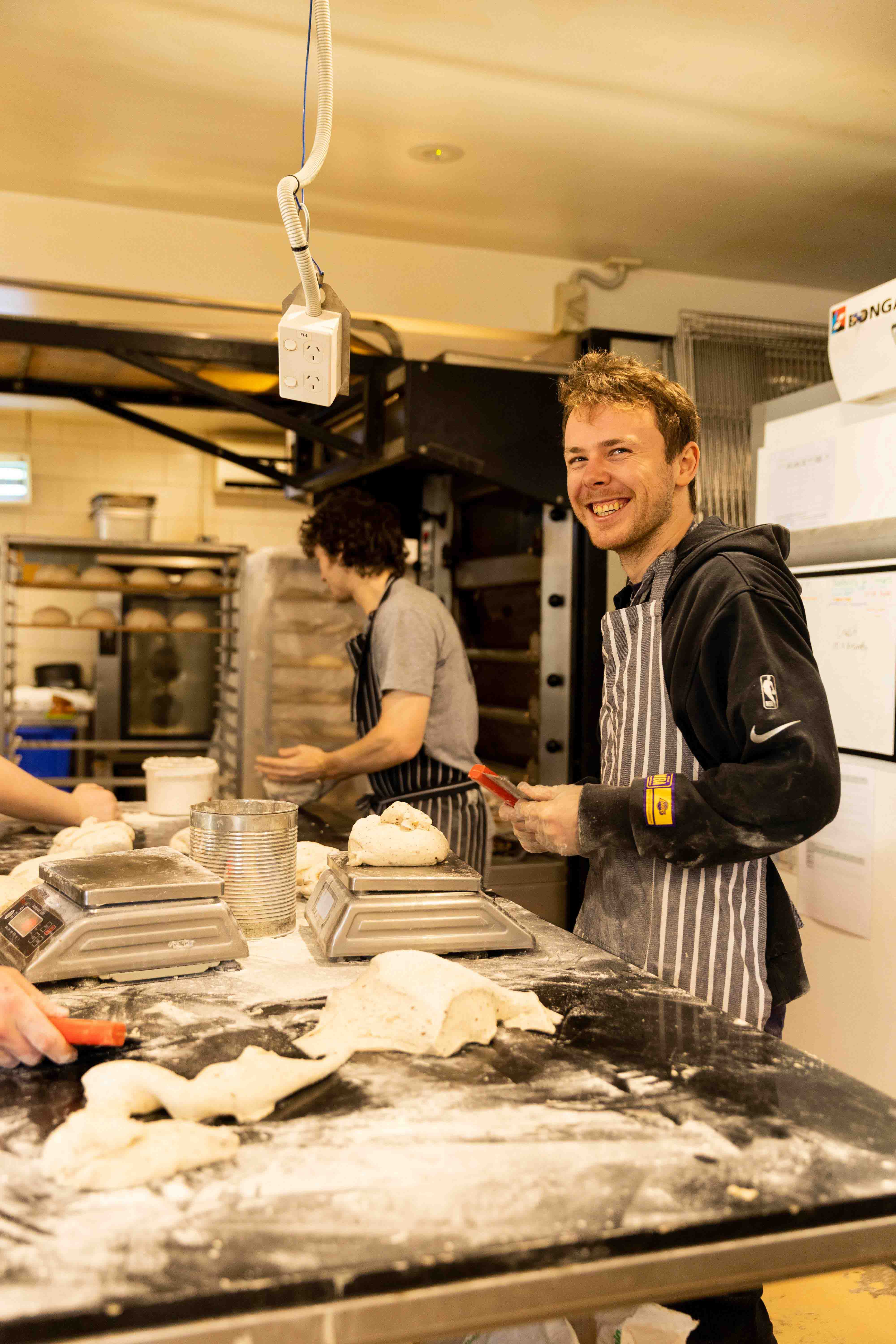 Bakers shaping dough in the Uraidla Bakery kitchen