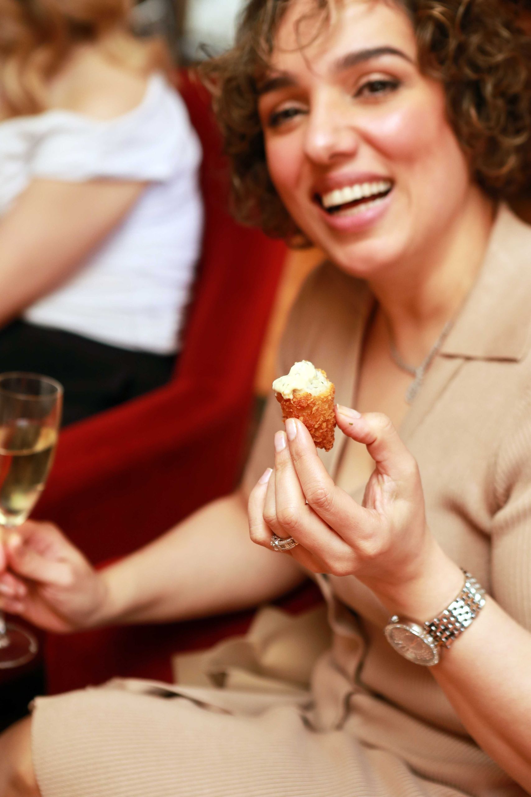 Guest enjoying a canapé with a glass of sparkling wine